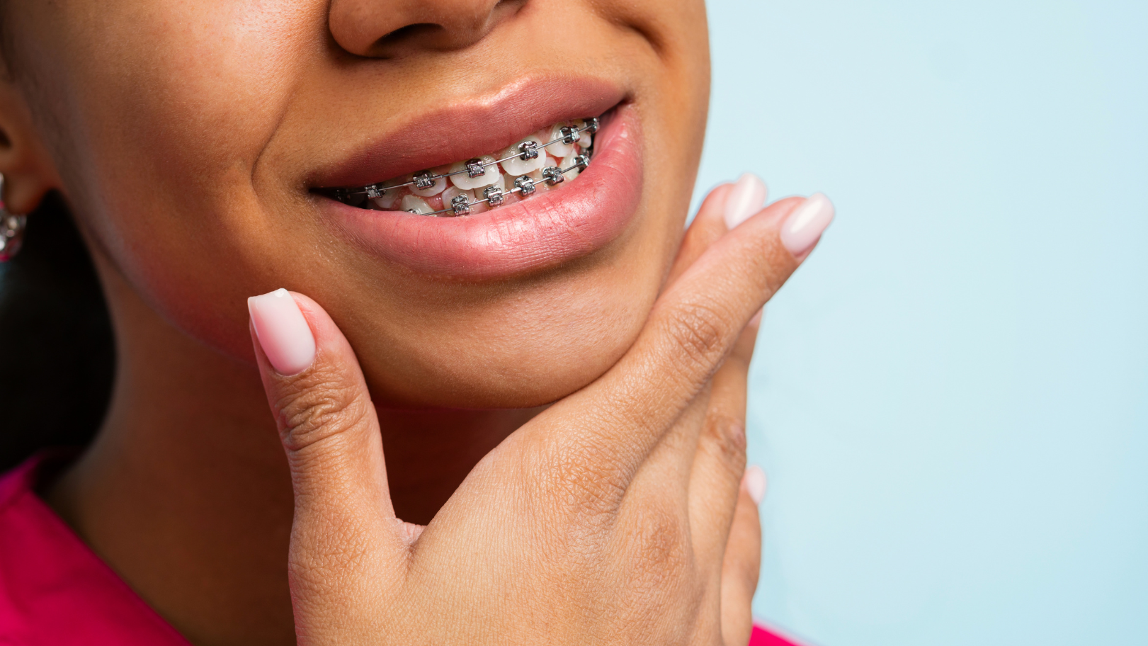 Girl with braces holding hand under her chin 